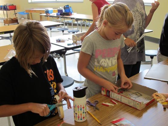 Two girls cutting paper